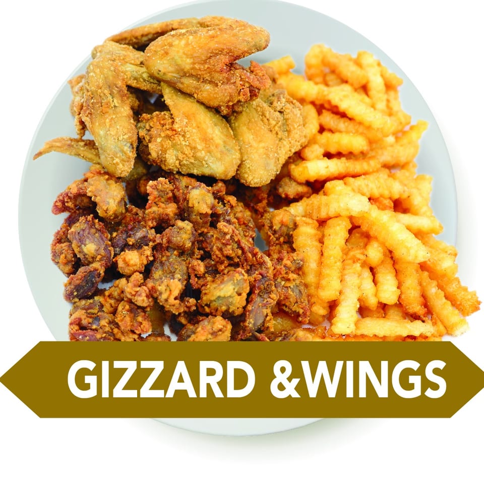 Plate of crispy fried chicken wings, gizzards, and crinkle-cut fries.